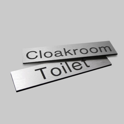 Engraved Sign with adhesive backing - 140x35mm dia Black text on aluminium effect