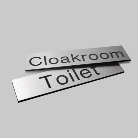 Engraved Sign with adhesive backing - 140x35mm dia Black text on aluminium effect